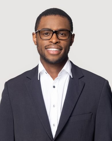 Smiling african American millennial businessman in glasses isolated on grey studio background posing, satisfied successful black male in formal suit wearing spectacles look at camera laughing